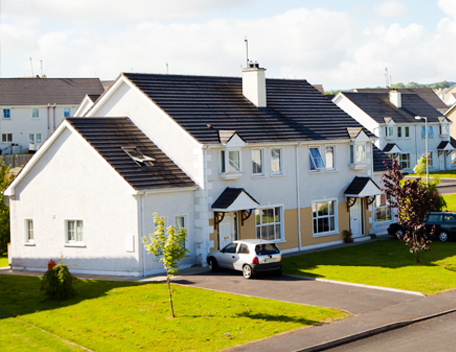 A row of houses with a green grass garden